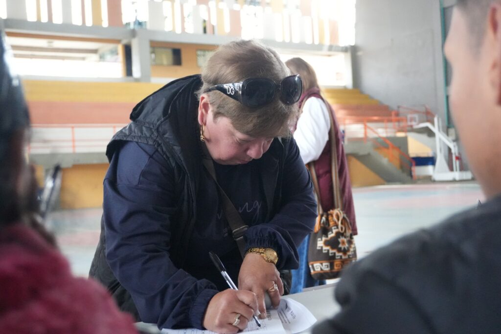Mujer diligenciando el formato de votación durante la elección del Consejo Consultivo Departamental de Mujeres en un puesto habilitado.