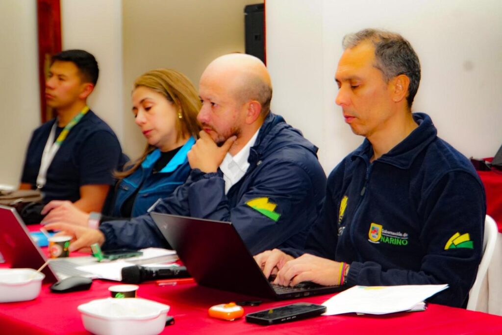 Equipo de la Gobernación de Nariño y la DAGRD reunido en mesa de trabajo con computadores portátiles realizando el monitoreo de la situación sísmica en el departamento.
