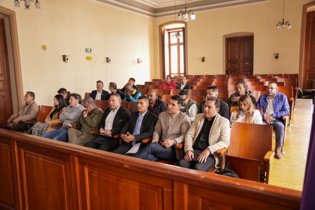 Asistentes y funcionarios sentados en las bancas de madera del recinto de la Asamblea Departamental durante el debate del proyecto hídrico para Ipiales.