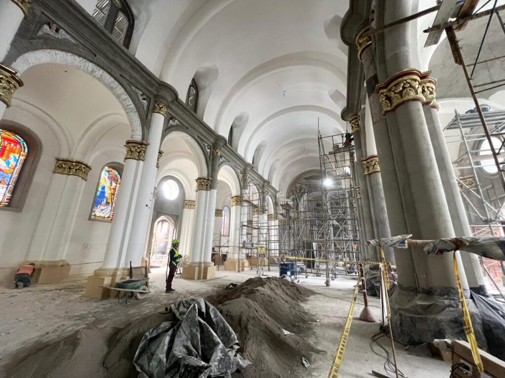 Interior del Santuario de Nuestra Señora de la Visitación en Ancuya con andamios y trabajadores avanzando en su restauración estructural.