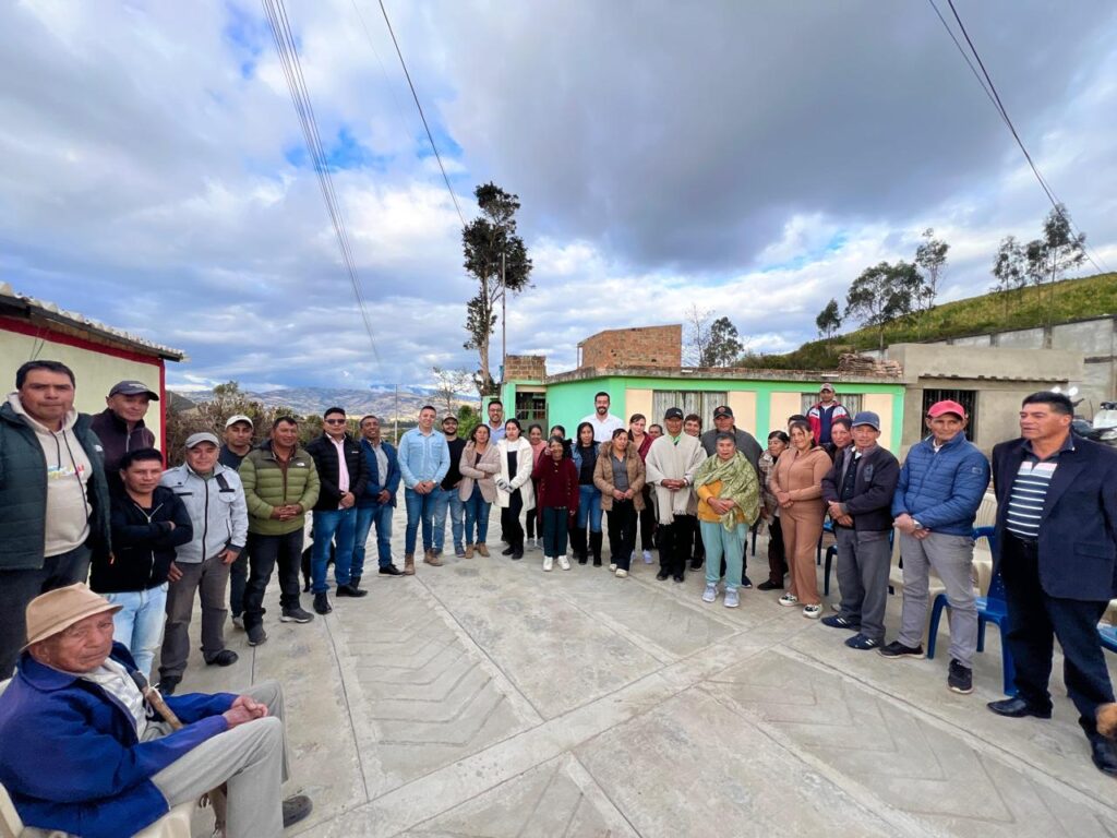 Grupo numeroso de habitantes rurales y líderes comunitarios reunidos sobre una nueva superficie de concreto bajo un cielo nublado en la subregión de La Sabana.