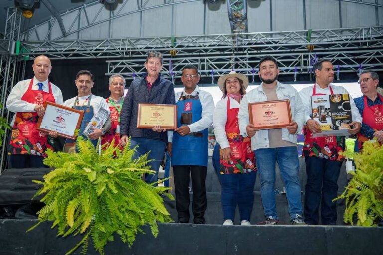 Grupo de hombres y mujeres en una tarima sosteniendo placas de reconocimiento del concurso Master Coffee y premios, acompañados por el Gobernador de Nariño.