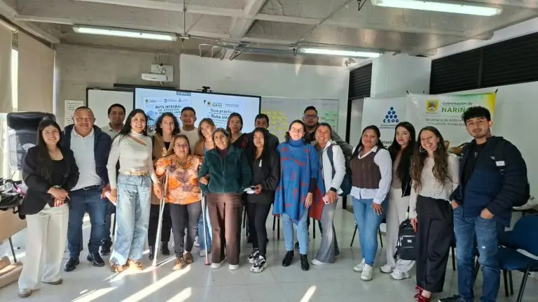 Foto grupal de los asistentes al taller de la Ruta Integral para la Atención del Maltrato Animal frente al pendón de la Gobernación de Nariño.