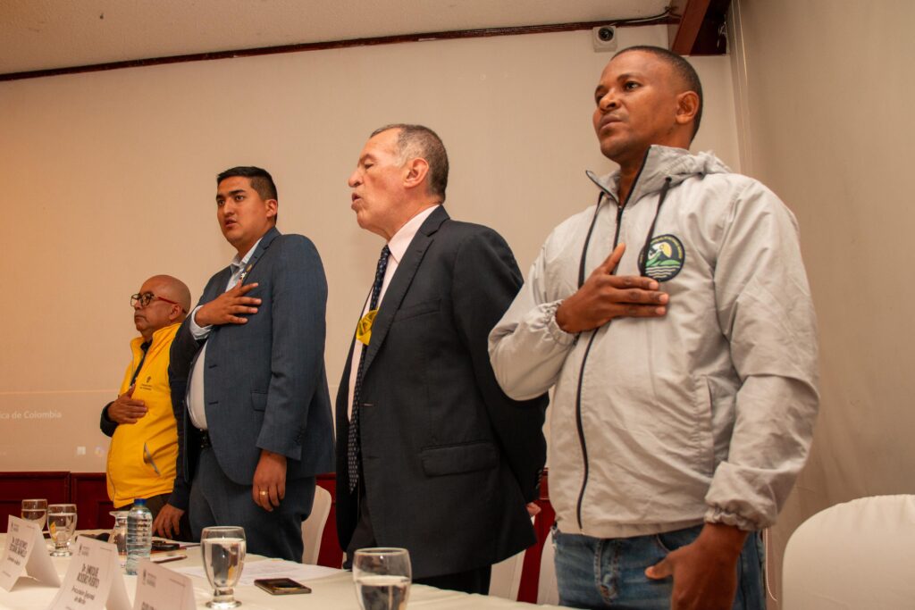 Cuatro autoridades e integrantes de la mesa principal de pie con la mano en el pecho durante los actos protocolarios del Comité Departamental de Justicia Transicional de Nariño.