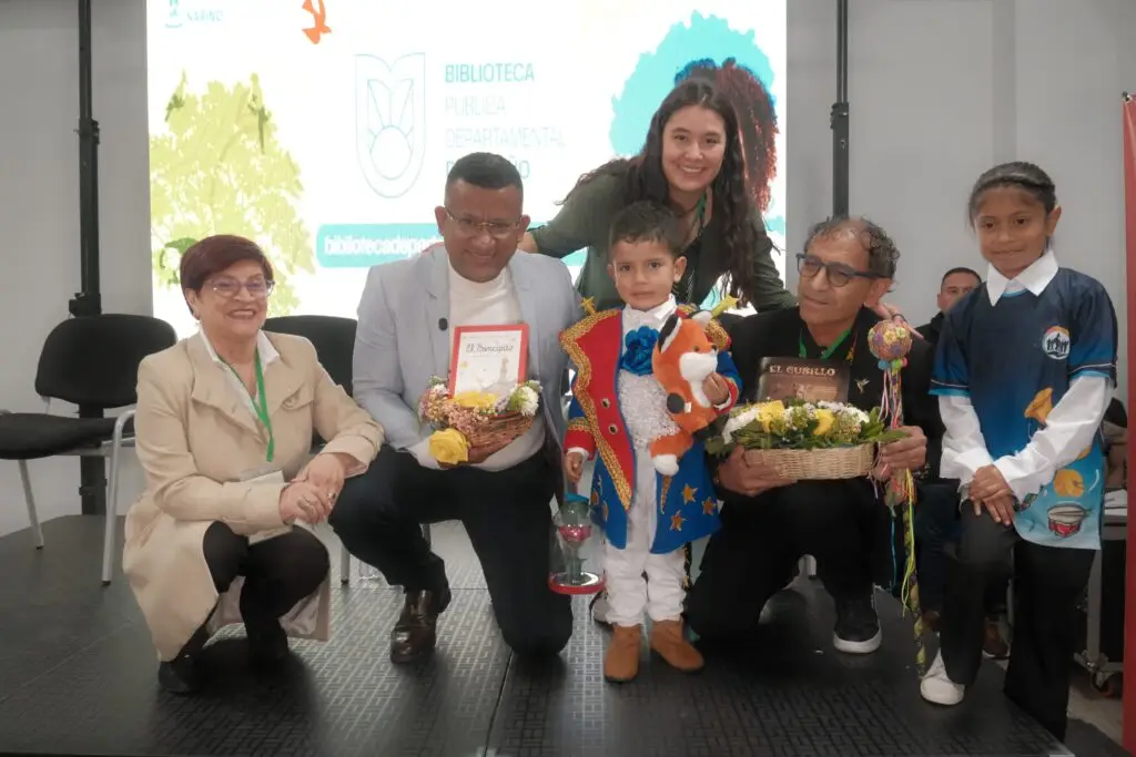 Niñas, niños y representantes institucionales posan con libros y elementos alusivos a la literatura infantil durante una actividad de la Biblioteca Pública Departamental de Nariño.