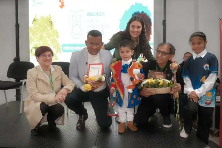 Niñas, niños y representantes institucionales posan con libros y elementos alusivos a la literatura infantil durante una actividad de la Biblioteca Pública Departamental de Nariño.