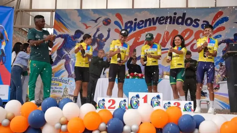 Ciclistas líderes de las distintas categorías destapando y festejando con botellas de champán en el podio decorado con globos en Funes.
