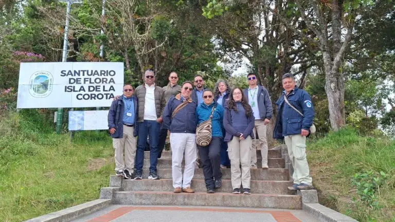 Representantes institucionales y ambientales posan junto al aviso del Santuario de Flora Isla de La Corota, en Nariño.