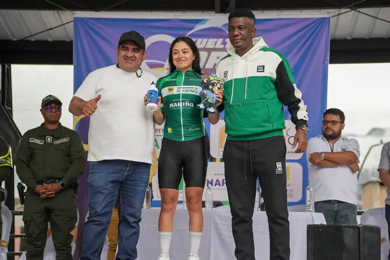 La ciclista Anahí Rosero Ceballos en el podio luciendo la camiseta verde de líder femenina de la Décima Vuelta a Nariño, acompañada por dirigentes deportivos.