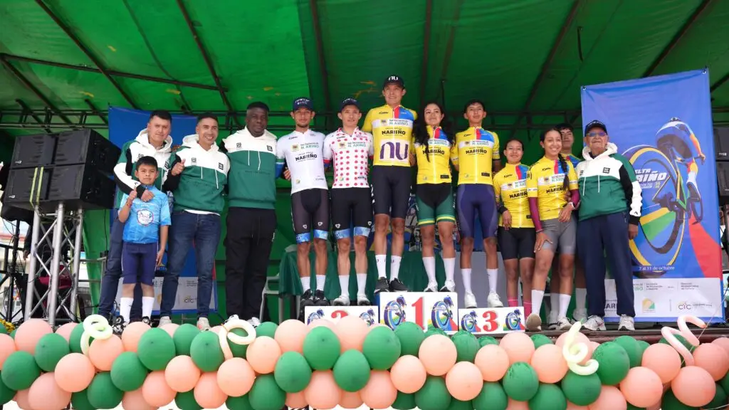 Cuadro de honor de la tercera etapa de la Décima Vuelta a Nariño en Iles con los líderes y ganadores de las distintas categorías posando en el podio institucional.