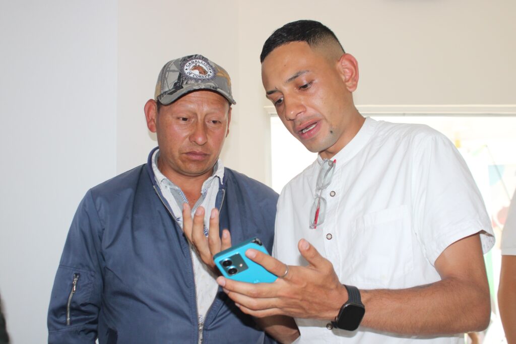 Dos participantes revisan información en un teléfono celular durante la jornada de construcción de la Política Pública Socioambiental Minera en Samaniego.