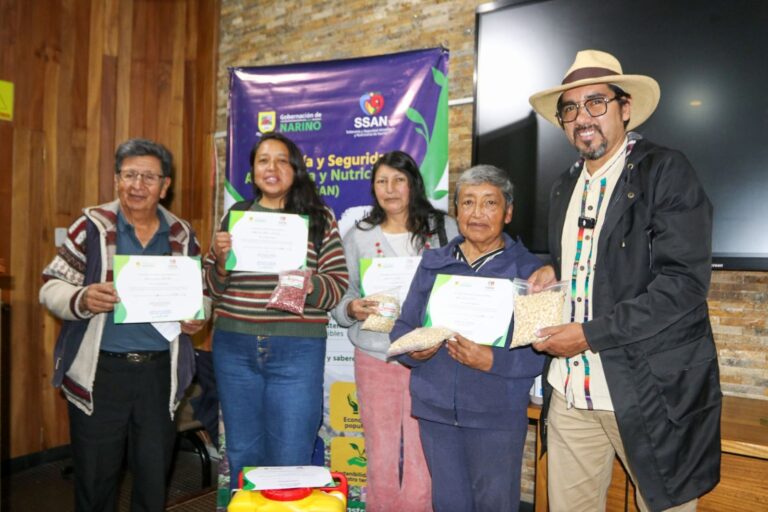 Campesinos y representantes institucionales posan con certificados y paquetes de semillas nativas durante una jornada de fortalecimiento de la soberanía alimentaria en Nariño.