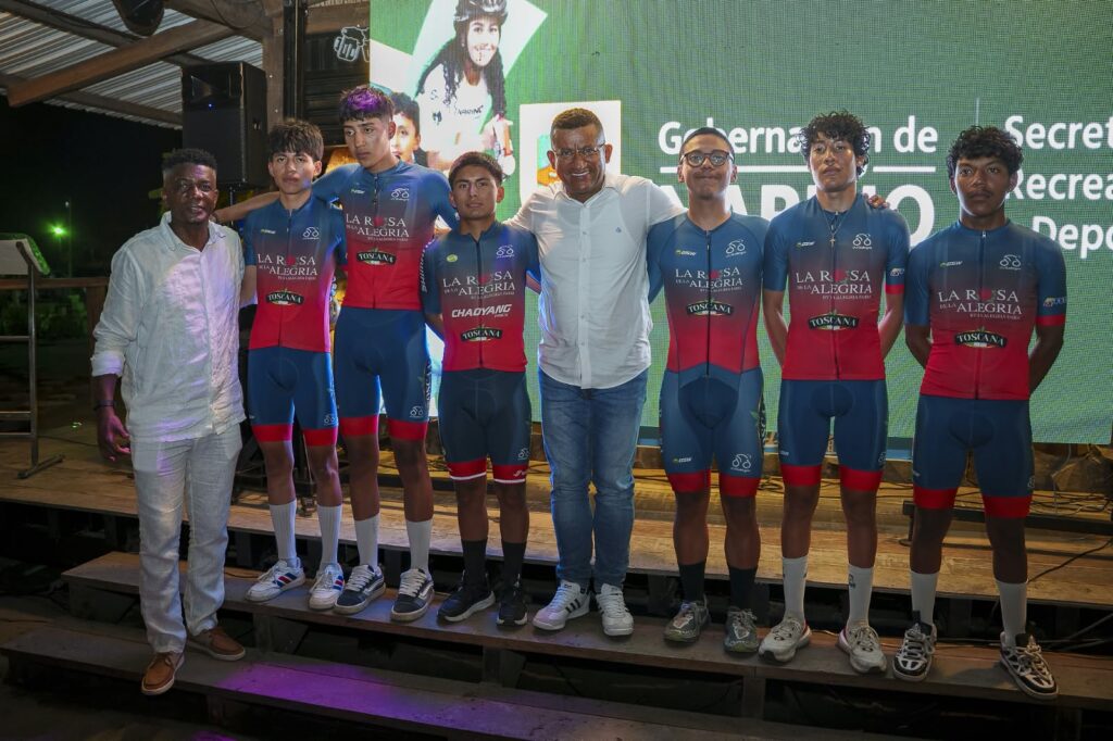 El gobernador de Nariño, Luis Alfonso Escobar, posando en tarima con los integrantes y directivos del equipo ciclístico JyJ Toscana durante la presentación oficial de la Décima Vuelta a Nariño en Tumaco.