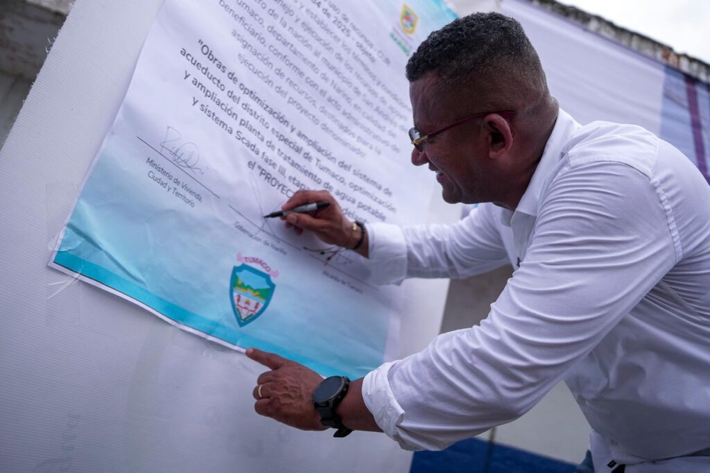 Gobernador de Nariño firma un documento durante la socialización de proyectos para fortalecer el sistema de acueducto de Tumaco.